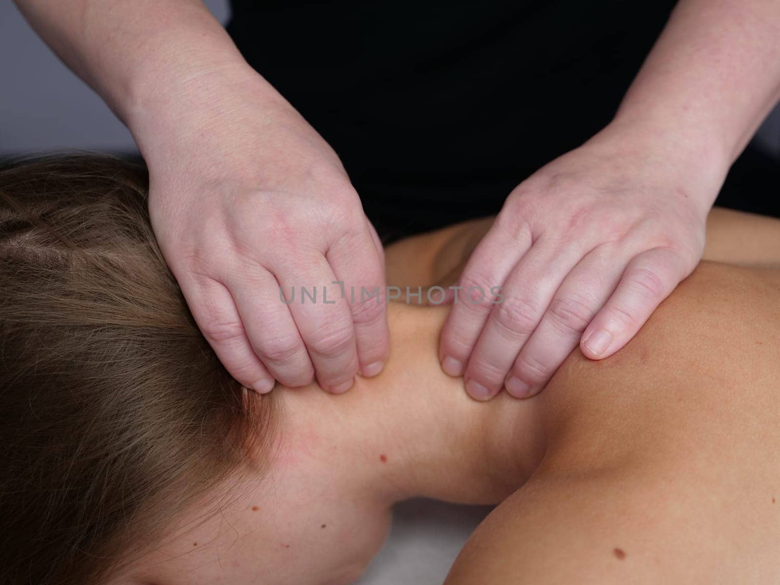 The masseur massages the neck for a woman's client to get rid of pain and discomfort in the body. close-up