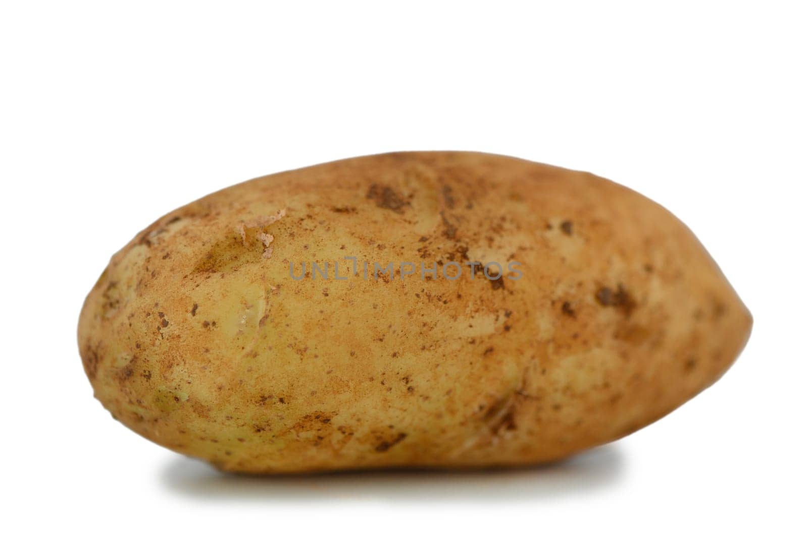 A rustic potato rests on a clean surface, highlighting its earthy tones and unique shape, exuding natural charm.