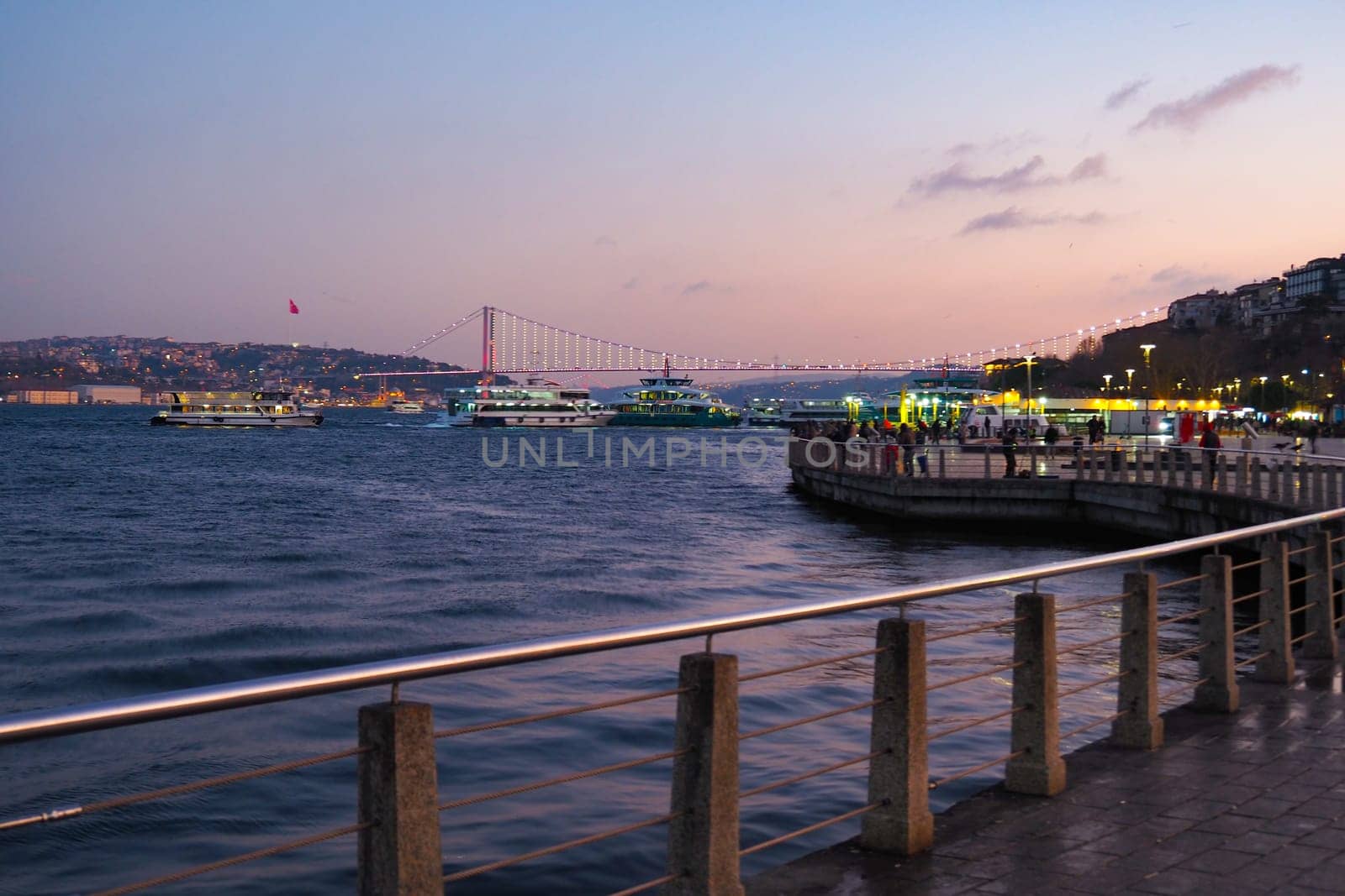 Boats traverse the water as the sun sets in Istanbul's harbor.