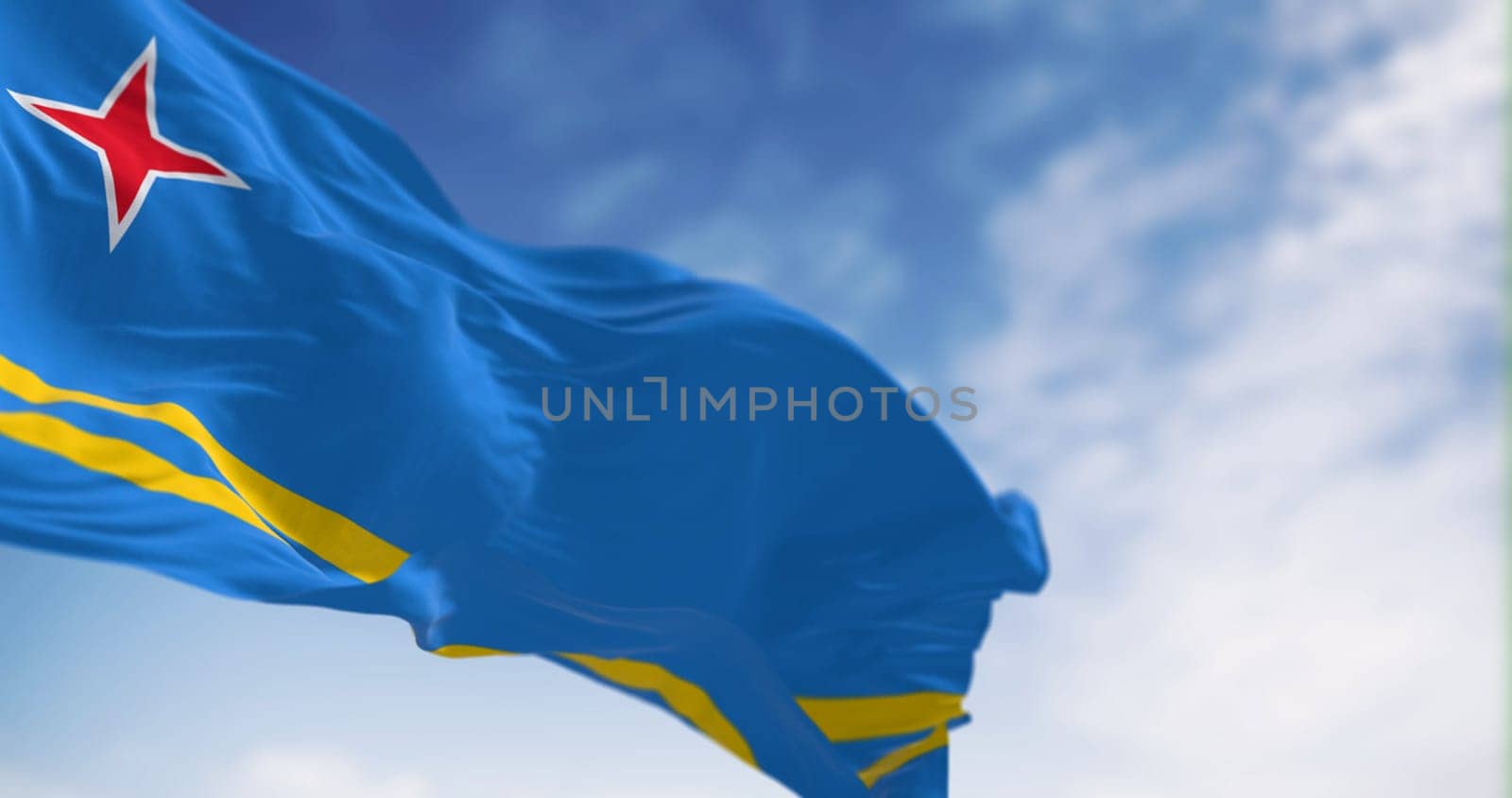 Flag of Aruba waving in the wind on a clear day. Light blue field, 2 yellow stripes, 4-pointed red star. Colors represent sea, abundance, peace, and origins. 3d illustration render. Selective focus