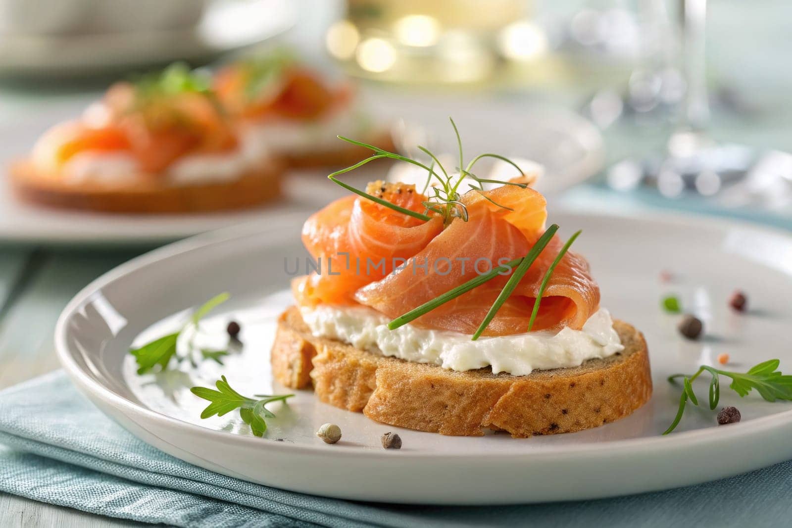 Savory open-faced sandwich features layers of smoked salmon atop a bed of cream cheese and garnished with fresh herbs. The setting is inviting with soft colors and elegant glassware.