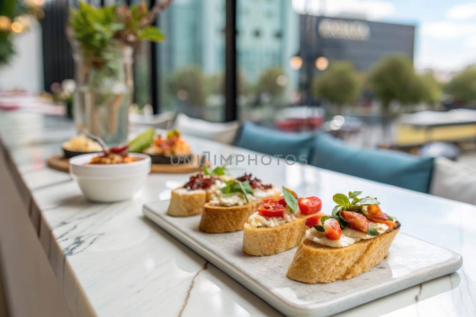 A selection of colorful appetizers is artfully arranged on a marble table in a stylish restaurant. Bright tomatoes, herbs, and garnishes create an inviting presentation, drawing attention.