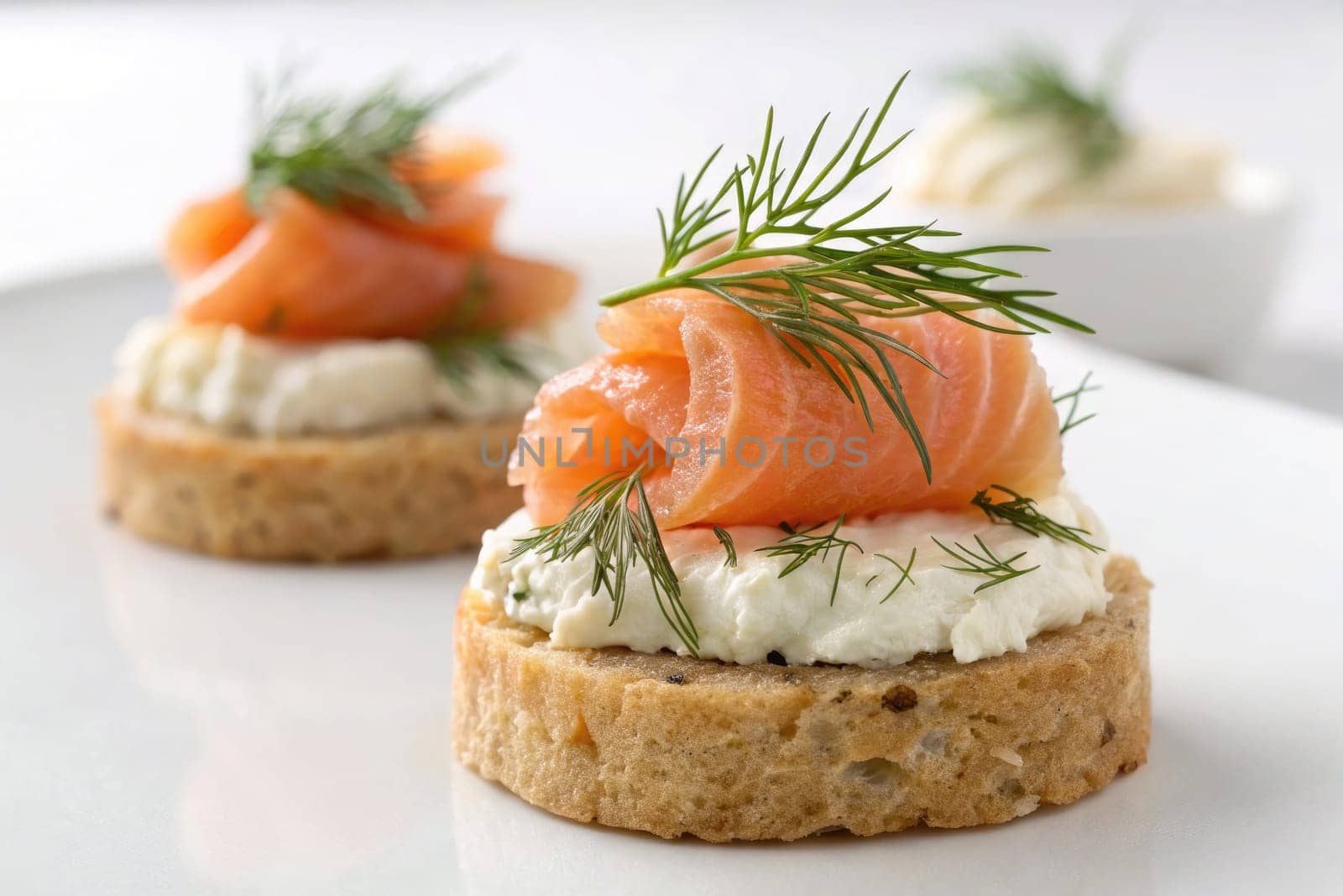 Two elegant hors doeuvres display slices of smoked salmon atop toasted rye bread and cream cheese. Fresh dill adds a bright touch to this appetizing arrangement, perfect for gatherings.