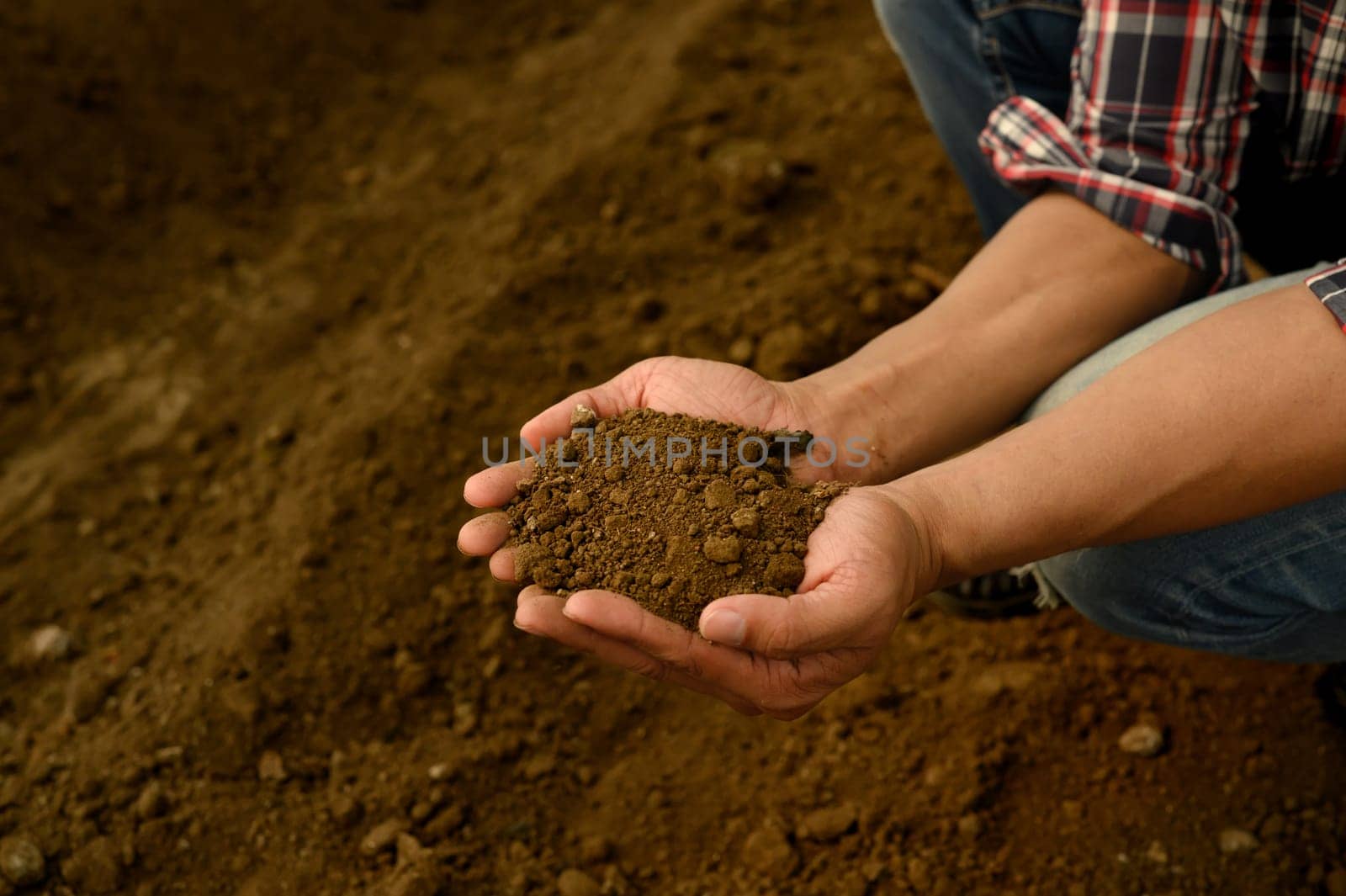 Farmer inspecting soil texture and composition, preparing for planting.