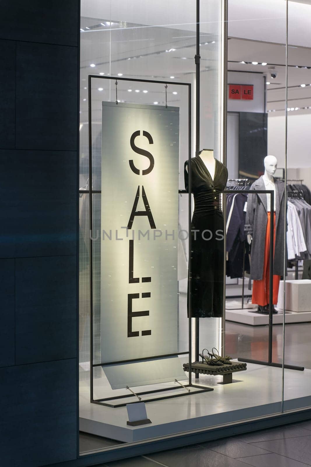 Illuminated shop window of a clothing store with the lettering Sale in the city center of Dresden, Germany