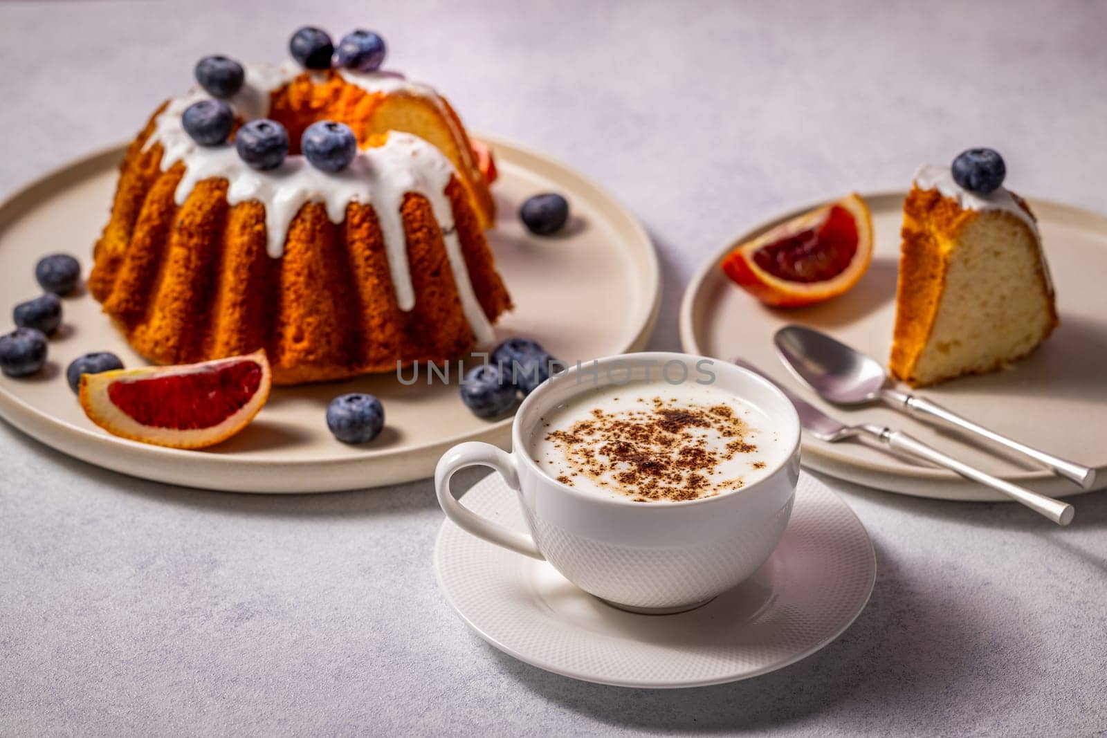Enjoying a perfect breakfast with fresh gugelhupf cake, blueberries, blood orange, and a cup of cappuccino