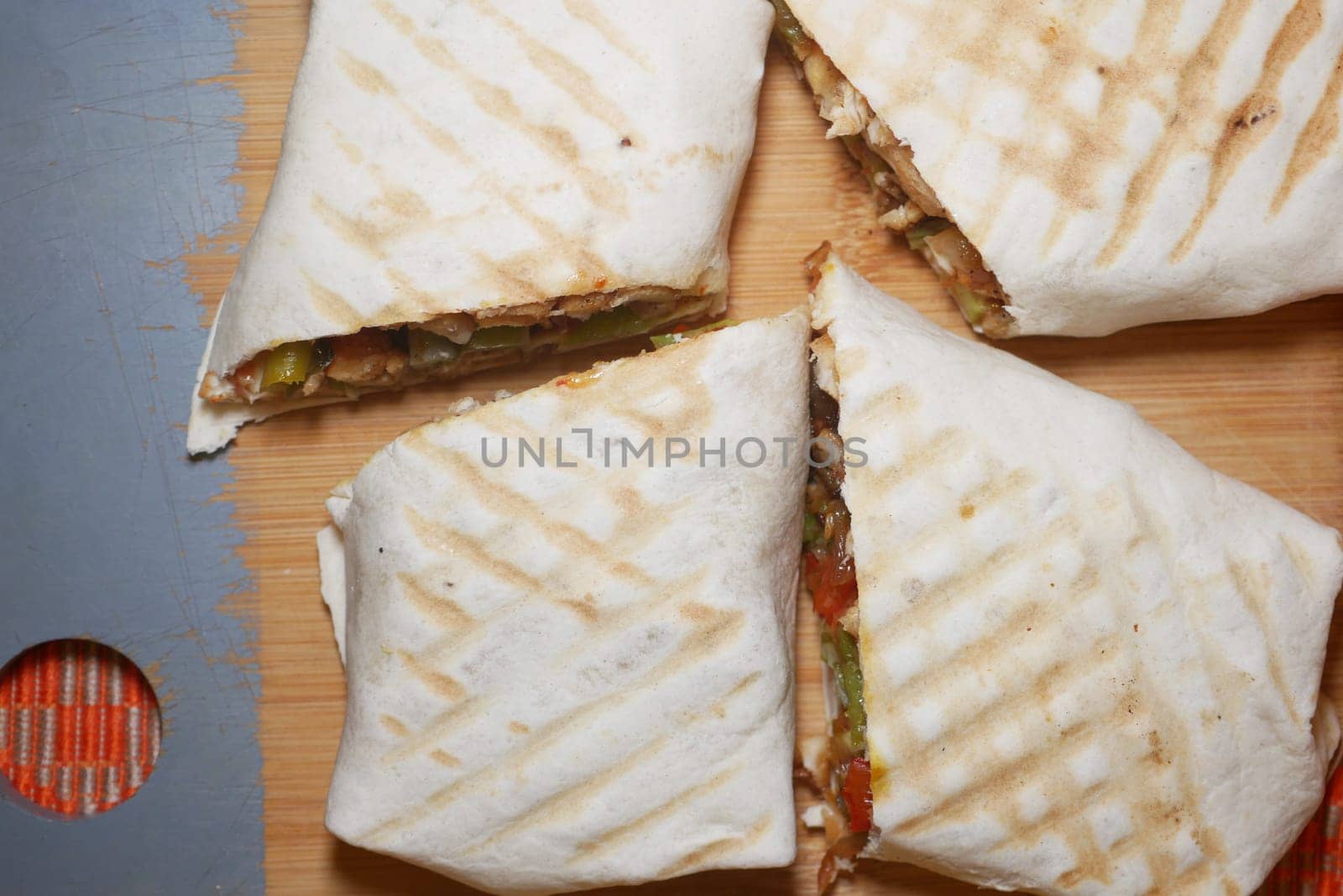 Tasty grilled wrap cut into quarters showcasing savory filling and crisping.