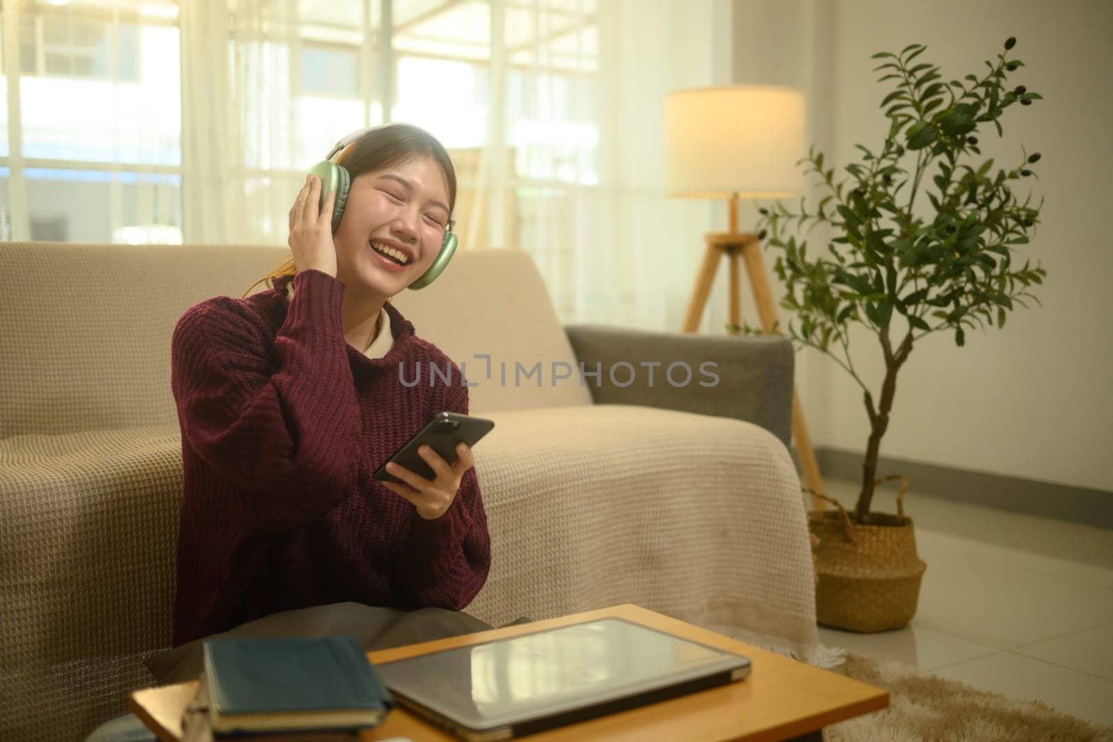 Happy young woman listening to music on wireless headphones and relaxation at home.
