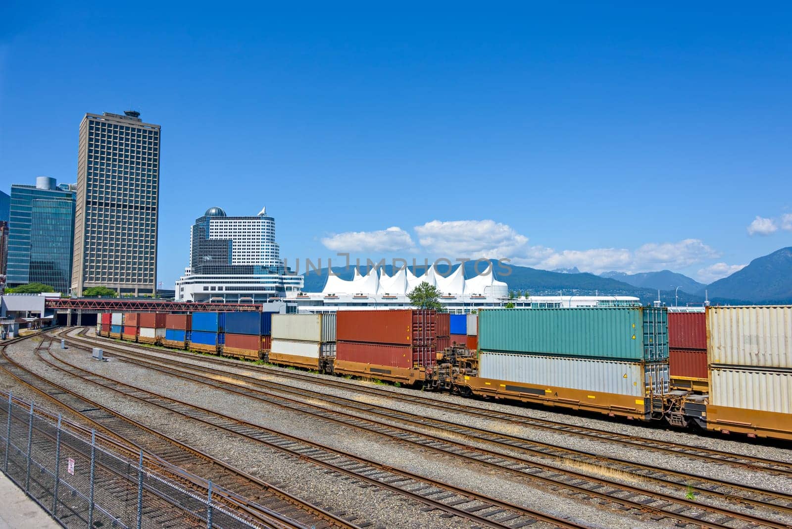 Container double cargo train going via downtown of Vancouver near by Canada Place palace.