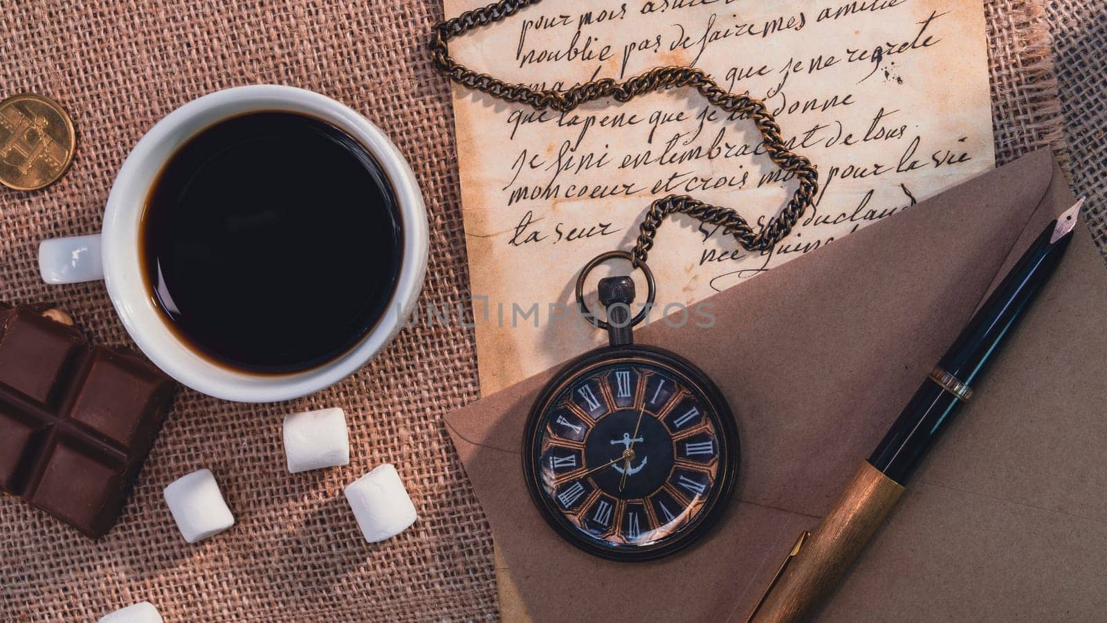 Vintage still life with a cup of coffee, a pocket watch, handwritten letters, a fountain pen, and chocolate on a burlap background. Warm and nostalgic atmosphere with retro elements