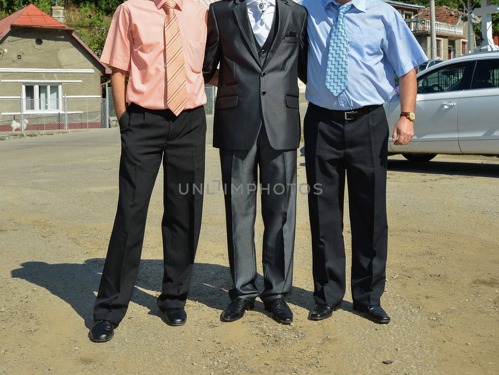 A group of people stand side by side, each wearing distinct formalwear, sharing in the spirit of the occasion