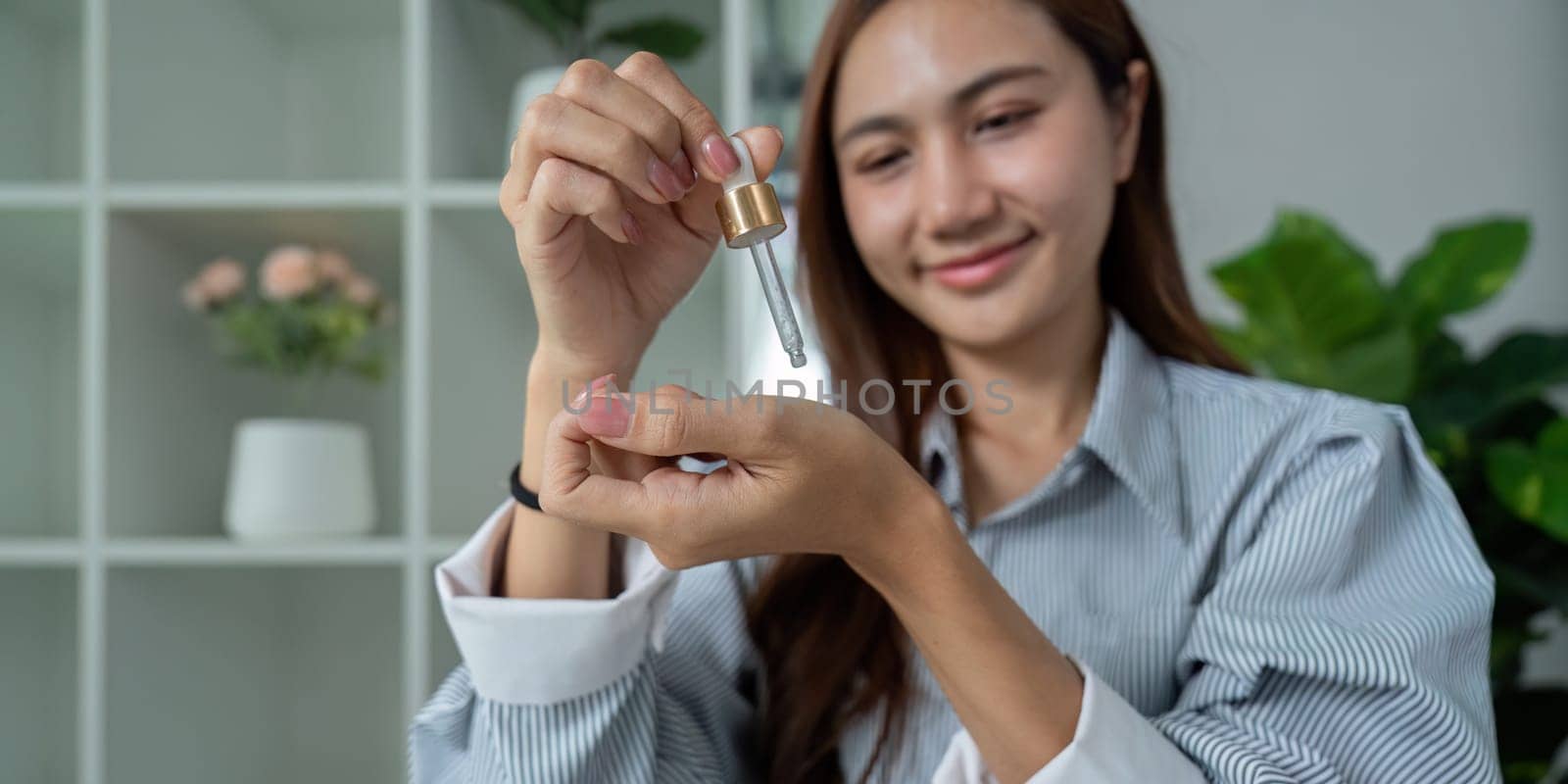 A woman showcases a dropper serum, reflecting her dedication to skincare. This image emphasizes self-care and the importance of quality ingredients for healthy skin.