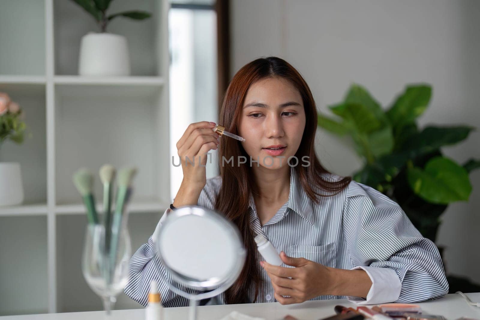 A skincare aficionado applies serum with precision, embracing the essence of beauty and health in her daily routine.