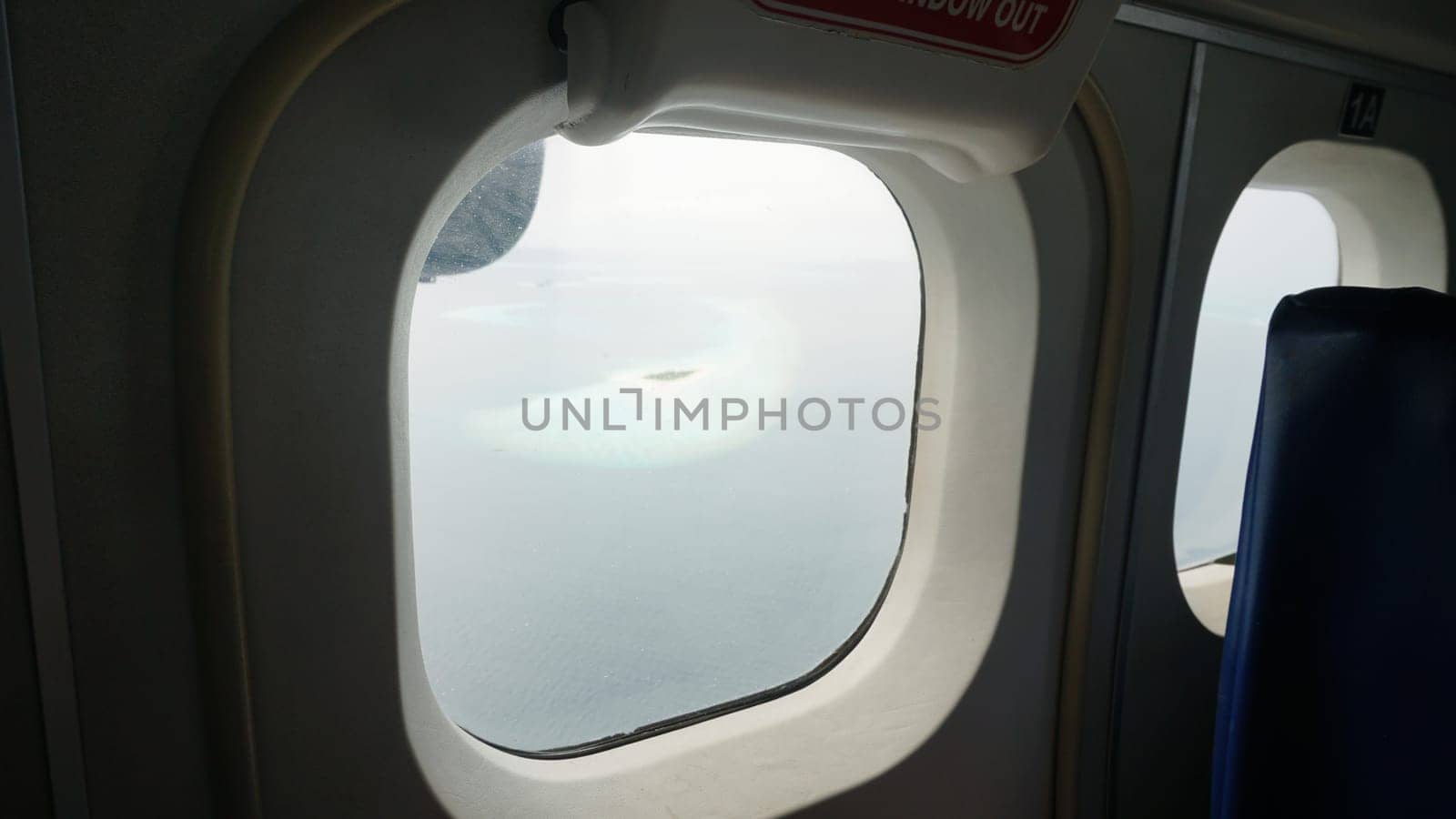 Gazing out from an airplane window, witnessing the breathtaking view of a tropical island in the maldives, featuring stunning turquoise waters and pristine white sand beaches