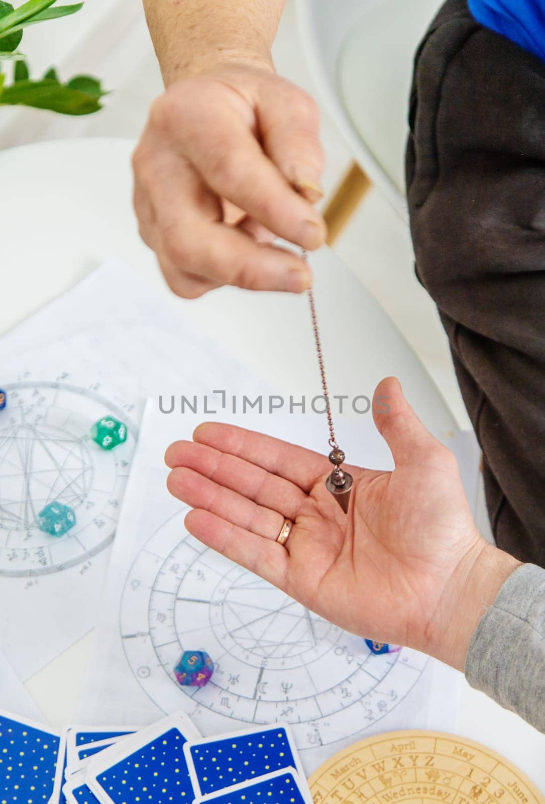 Pendulum fortune telling and astrology. Selective focus. people.