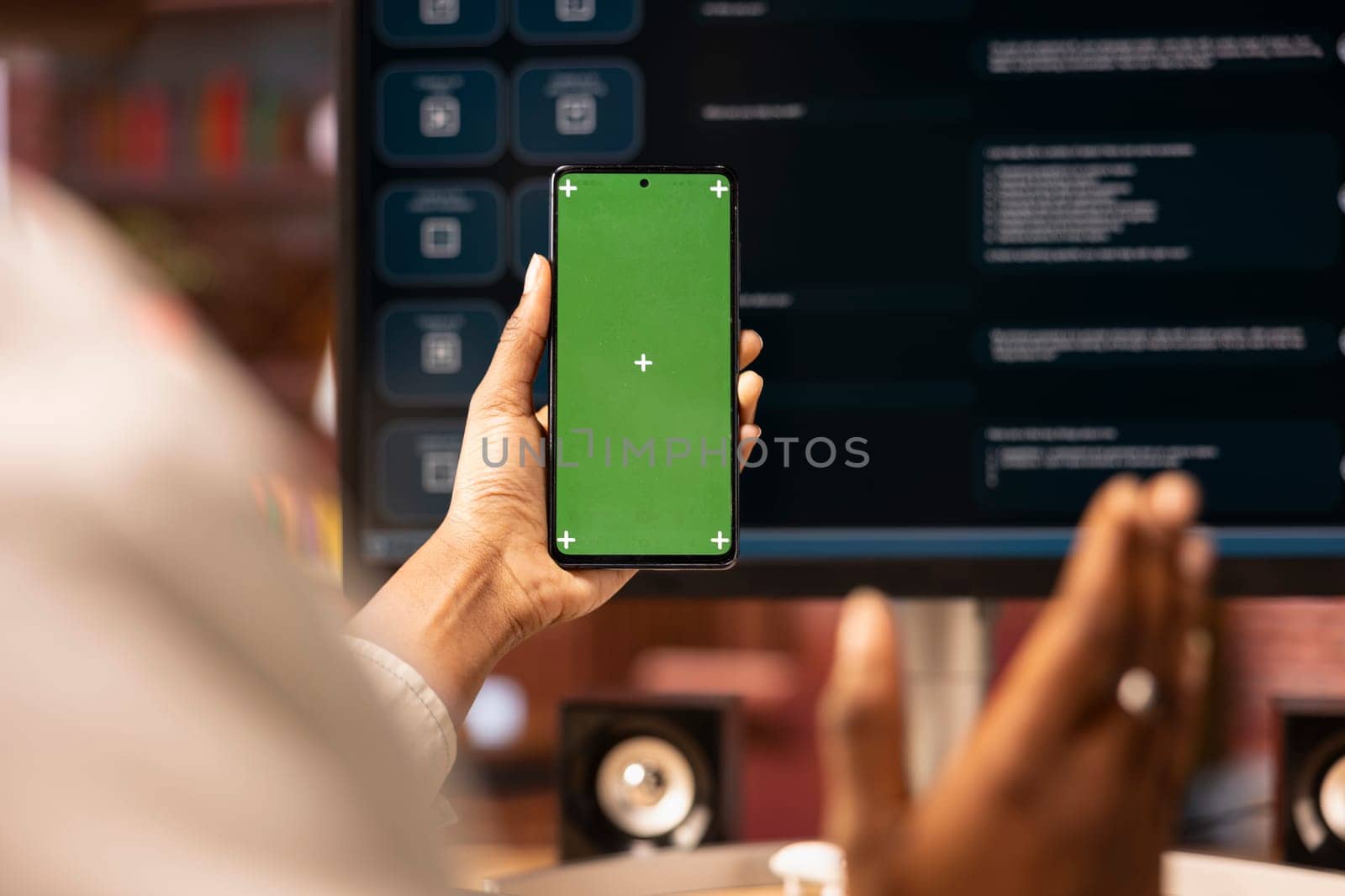 Woman uses isolated screen phone, doing online videocall in front of PC screen with AI LLM chatbot, close up. Person uses large language model program during teleconference on chroma key smartphone