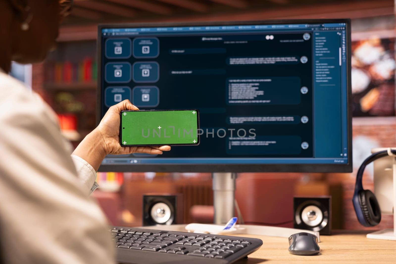 Woman using mockup smartphone to look at video tutorials on AI chatbots in home office. Person holding green screen phone to look at visual guides on artificial intelligence LLMs