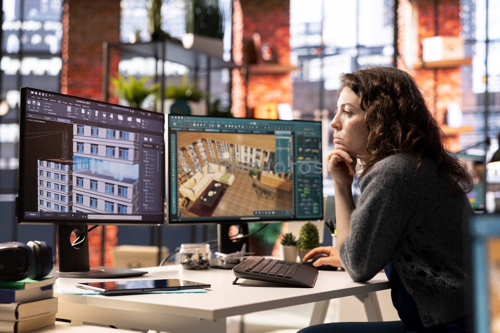 Female employee at design agency creates 3D render of an apartment interior using architectural software. Employs computer aided tools to allow customization of furniture and flooring.