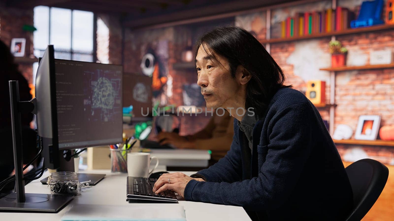 Software engineer in small business workspace using computer to oversee artificial intelligence neural networks. Person in tech startup office using AI machine learning systems on PC, camera B