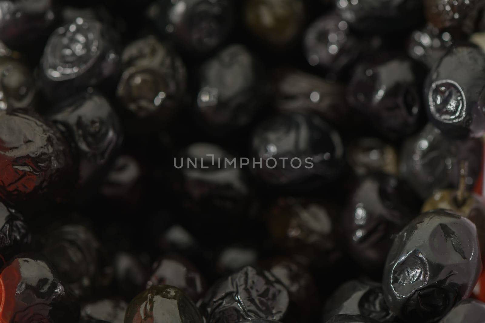 Silky black olives glisten in a vintage bowl, inviting culinary creativity. Their rich textures suggest an upcoming feast centered on vibrant flavors and shared enjoyment.