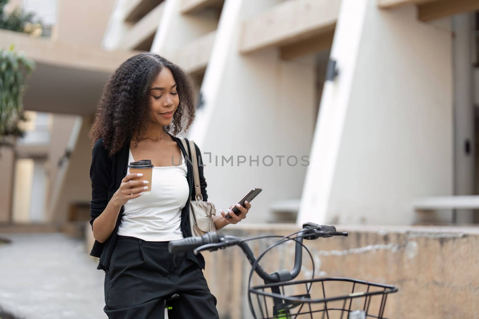 In a cozy urban setting, a woman takes a moment to enjoy her coffee and check her phone, emphasizing a modern yet relaxed approach to daily commuting.