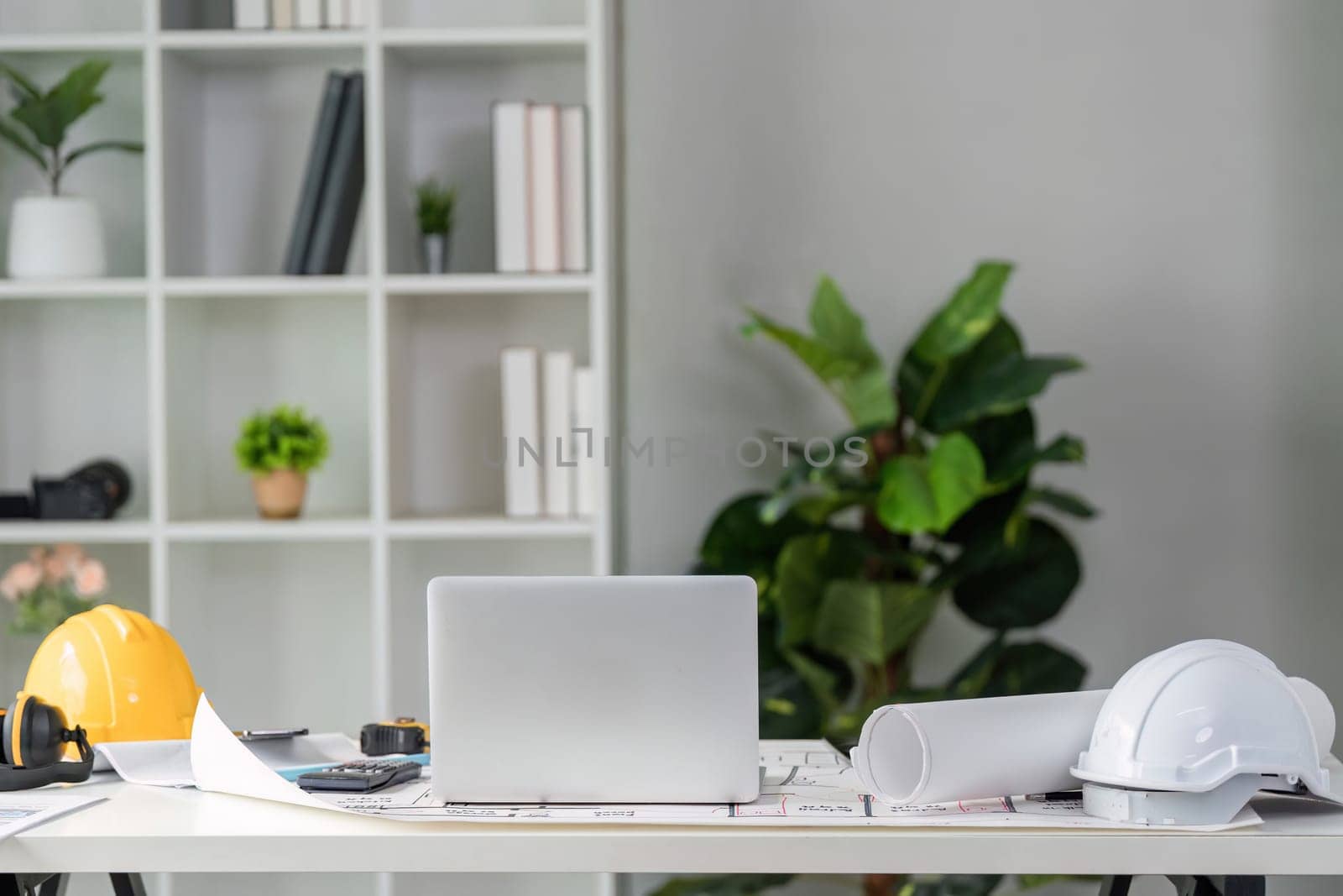 A well-arranged workspace emphasizing productivity in construction, showcasing essential tools, digital devices, and plant decor to create a vibrant environment.