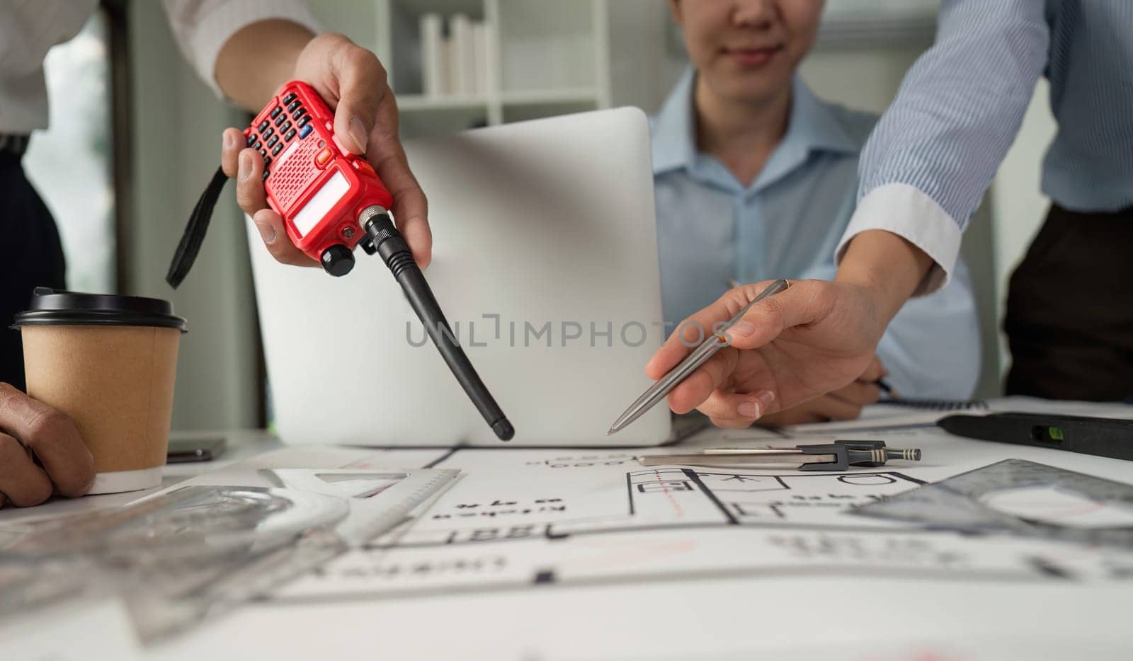 A team actively collaborates and communicates about architectural plans using walkie-talkies to enhance information flow and project coordination.