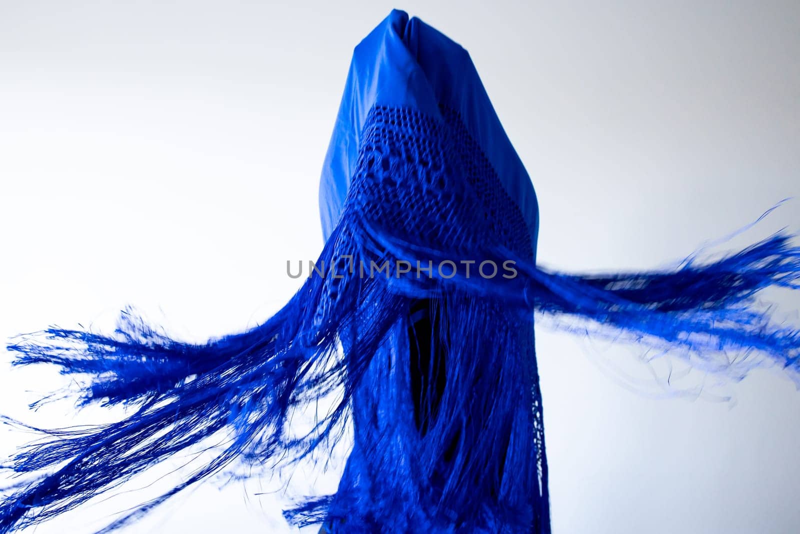 Abstract blue fabric art with dynamic fringes and geometric shapes.