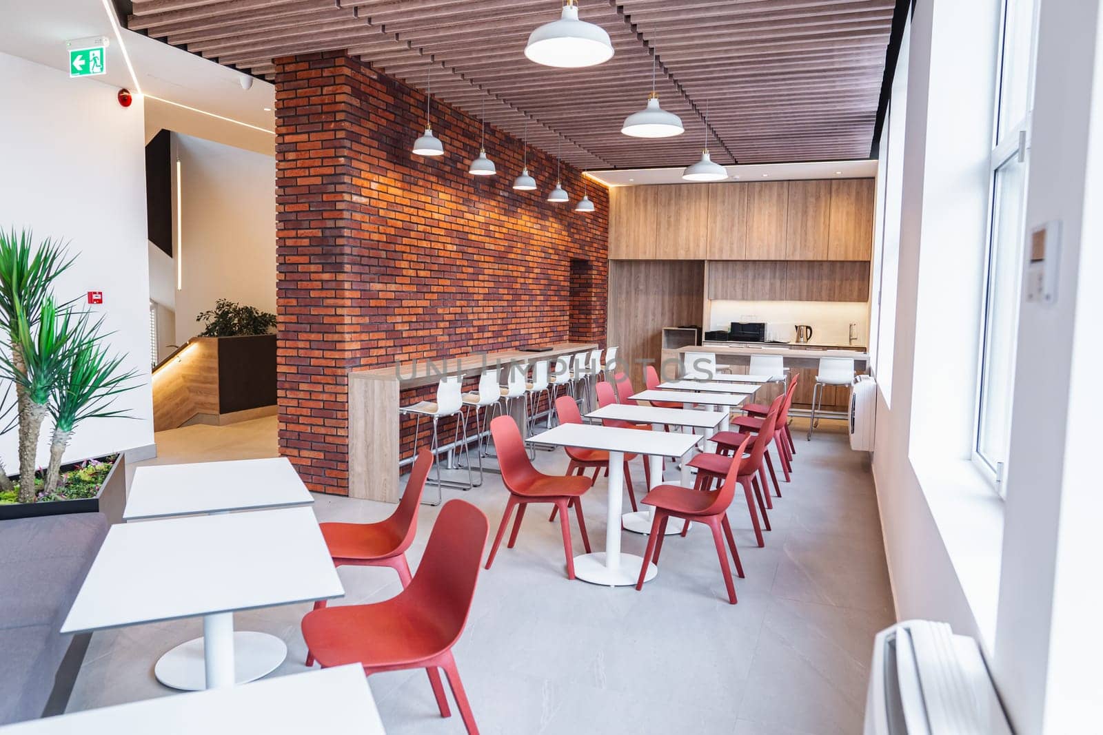 The image showcases a typical restaurant setting with neatly arranged tables and chairs against a textured brick wall. The interior exudes a cozy and inviting ambiance perfect for dining.