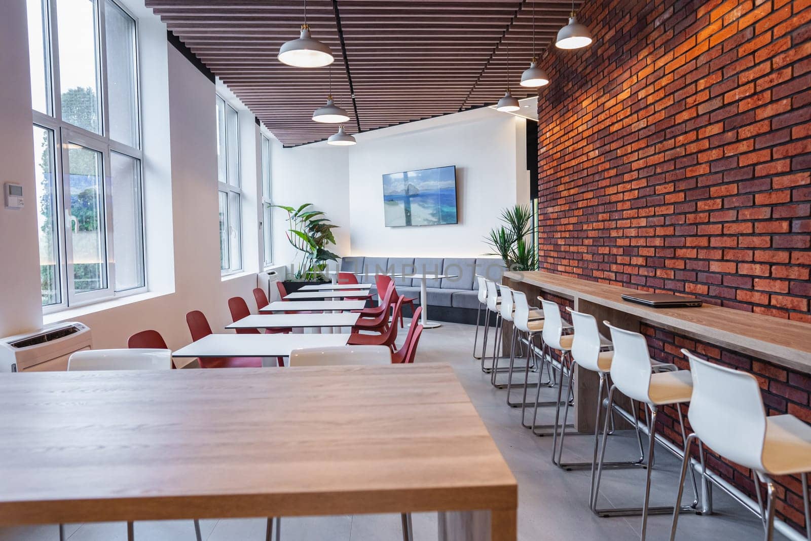 The room is densely packed with numerous tables and chairs, creating a busy and functional space for gatherings or events. The tables are varied in size and shape, while the chairs are lined up neatly around them, suggesting a planned arrangement for seating.
