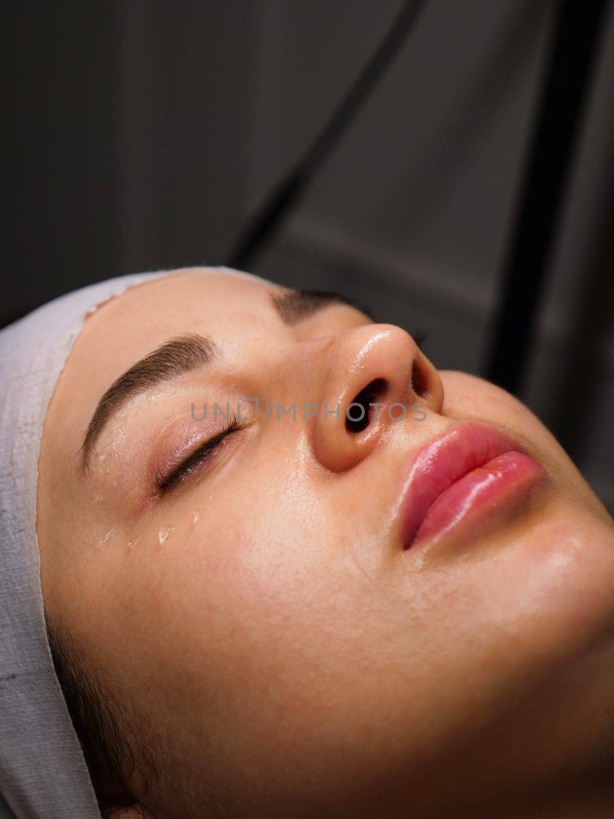 Anti-wrinkle moisturizing gel for the face around the eyes for the eyelids. Women's care at a beautician, close-up, vertical