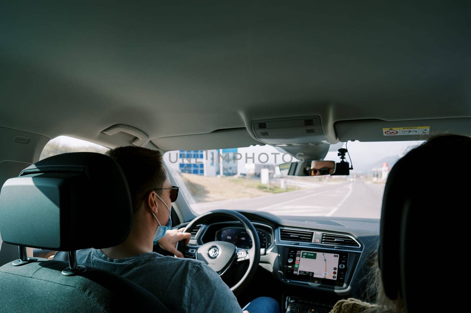 Man is driving a car on the road. Back view. High quality photo