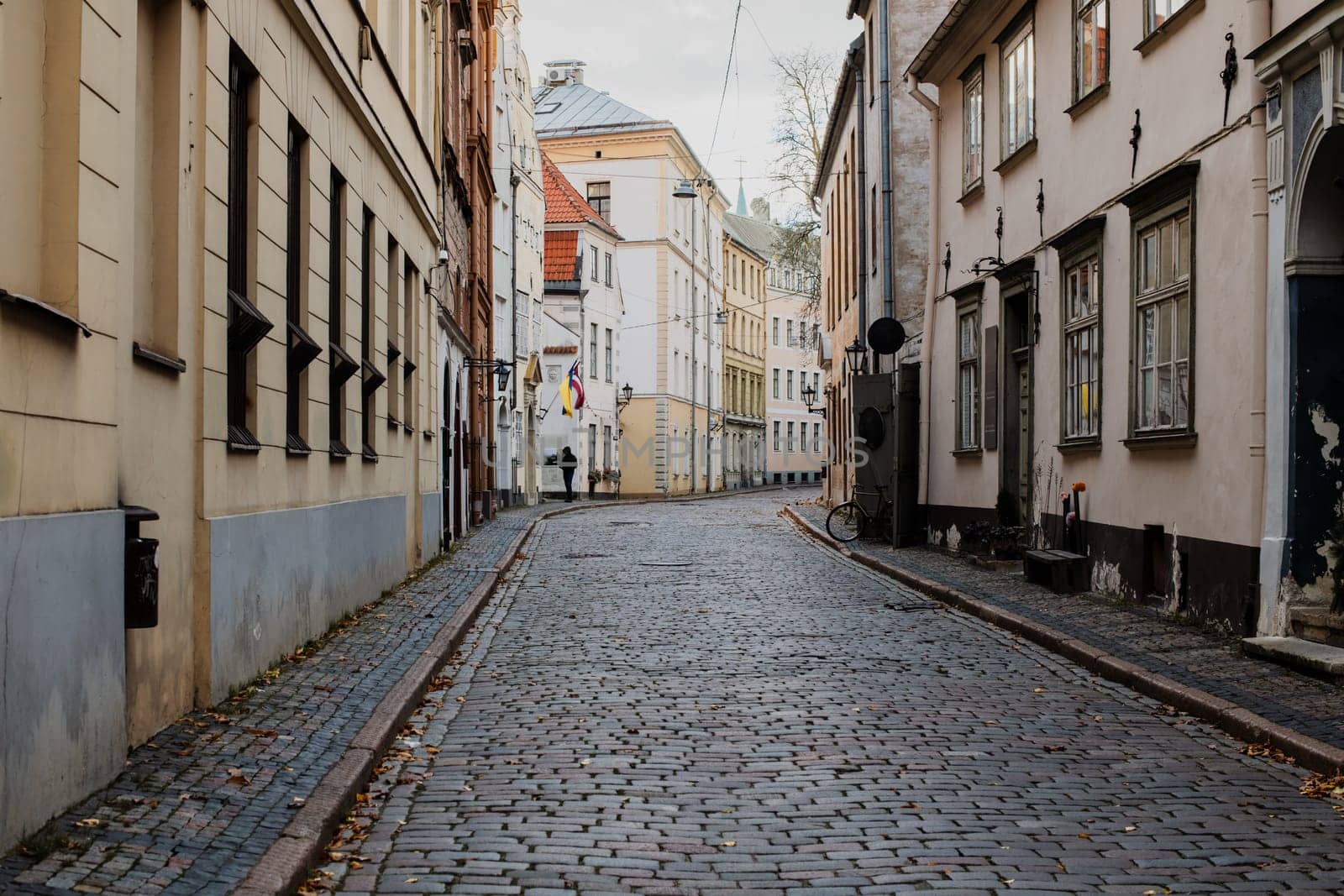 A beautiful European city square bathed in warm sunlight. The cobblestone pavement reflects the golden rays of the setting sun, while historic buildings with elegant facades frame the scene.