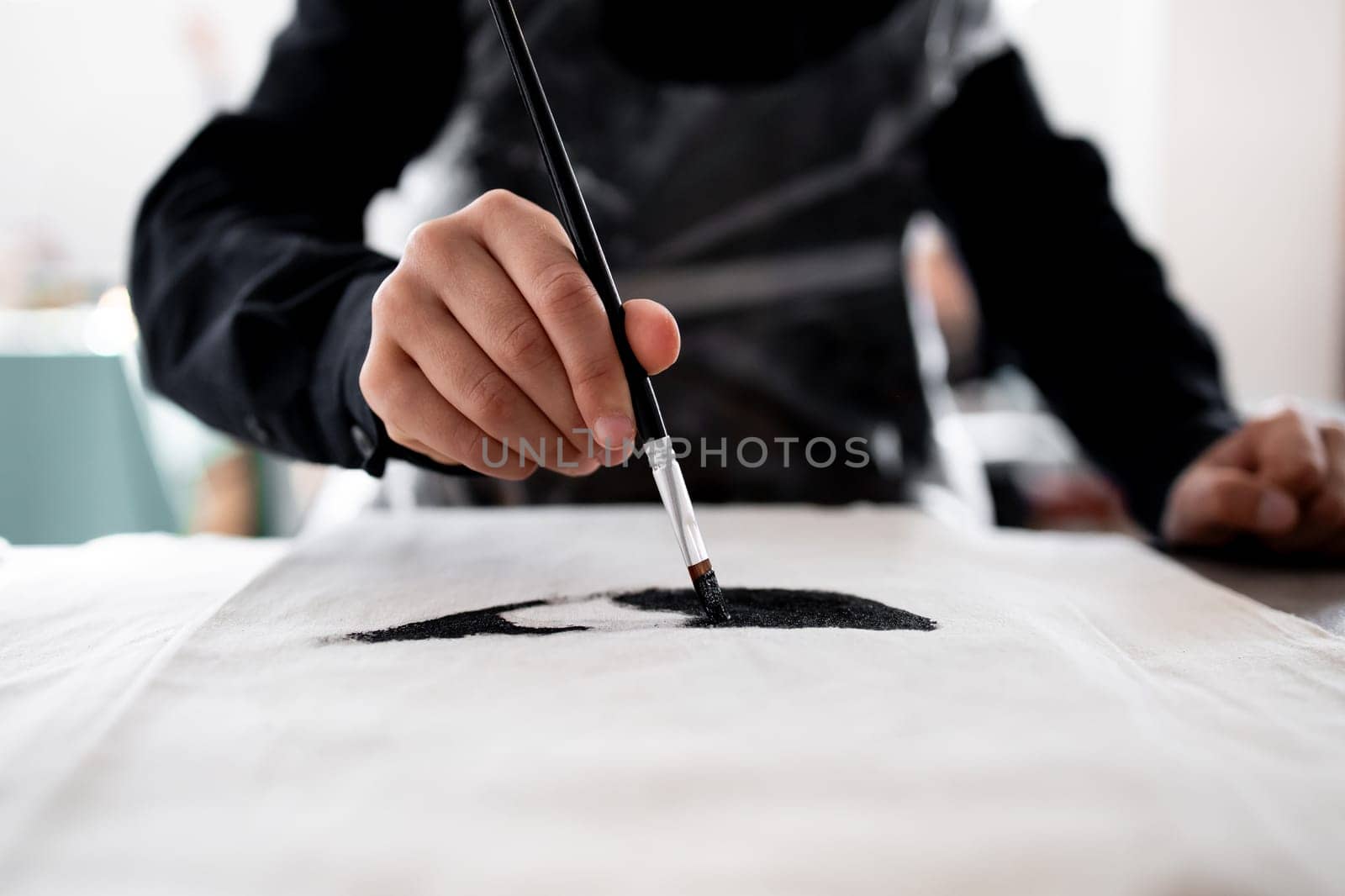 Close up of artistic hand painting on fabric with precision and skill.