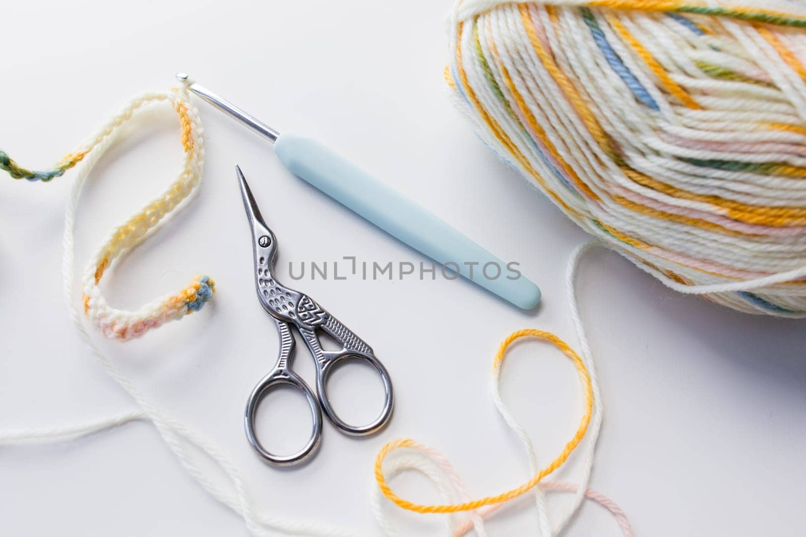 Colorful yarn with crochet hook and scissors for crafting projects.