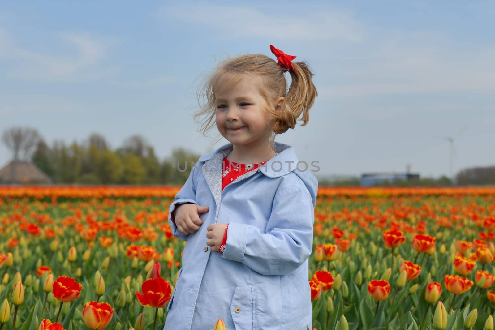 Happy girl running in a orange tulip field