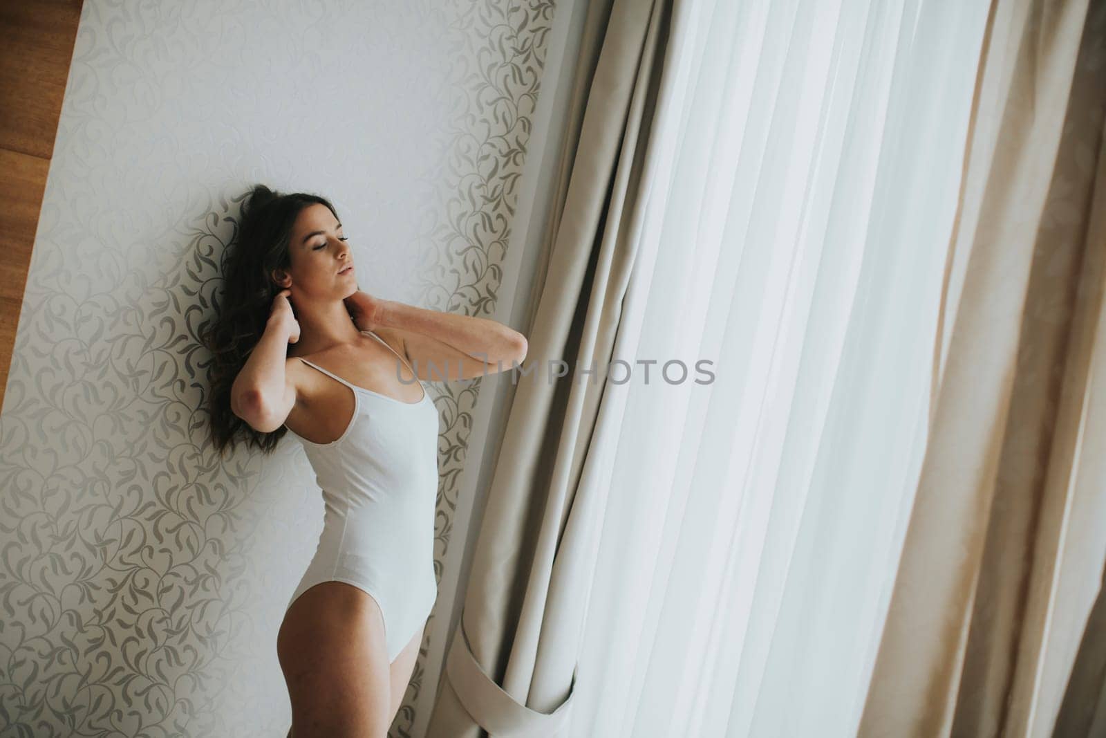 Pretty young woman by the window in the room
