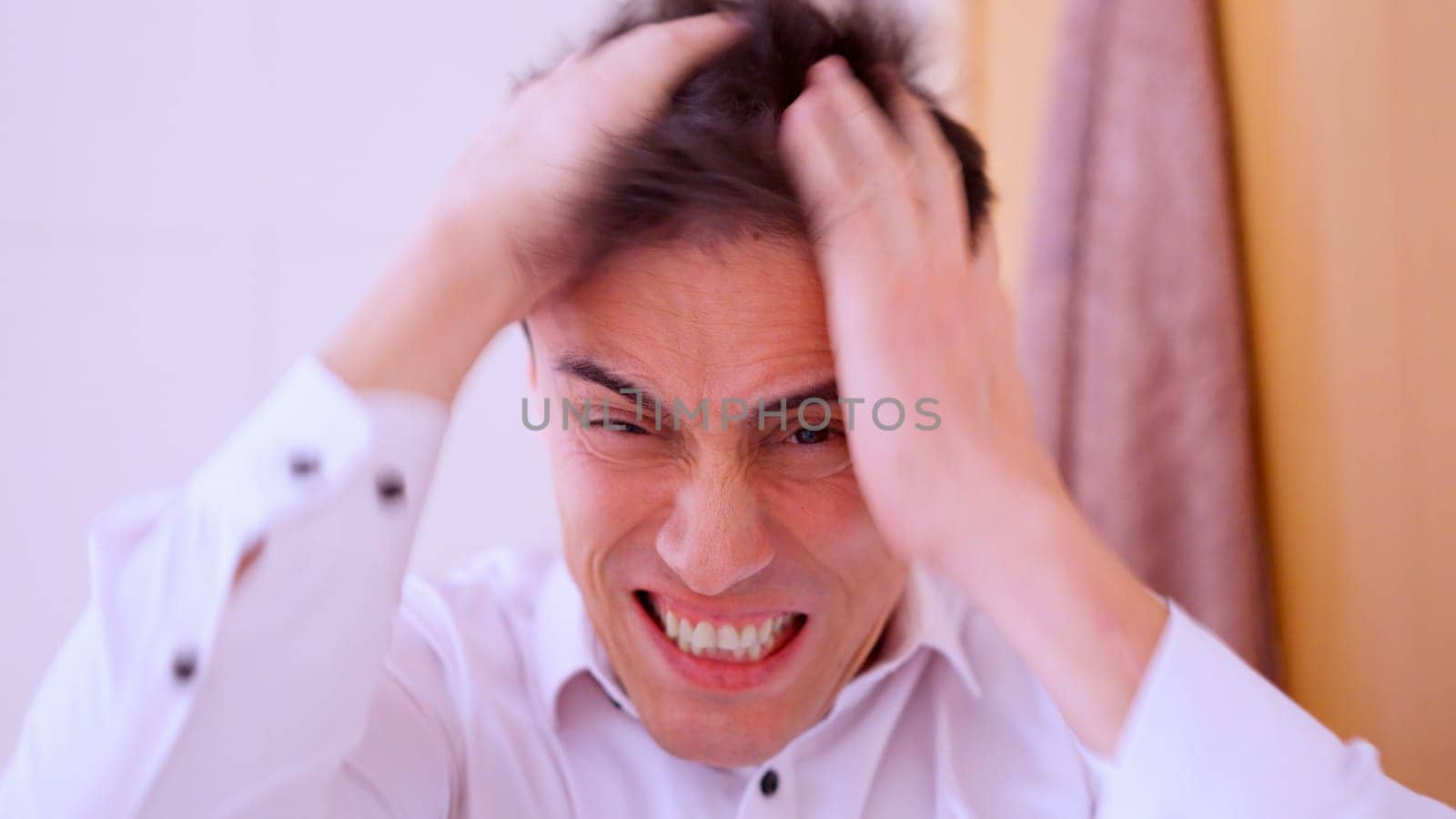 Office worker experiencing extreme stress and anxiety, pulling his hair in a moment of desperation