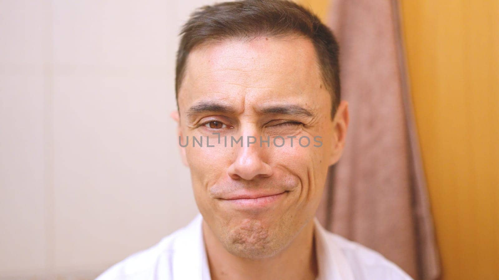 Man winking and smiling while getting ready in his bathroom in the morning
