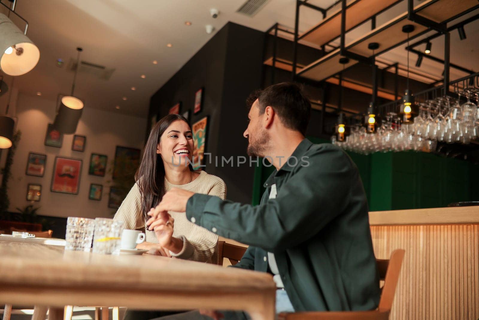 Two friends share laughter and warm drinks at a charming cafe, creating an inviting atmosphere that celebrates connection and joy during a sunny day