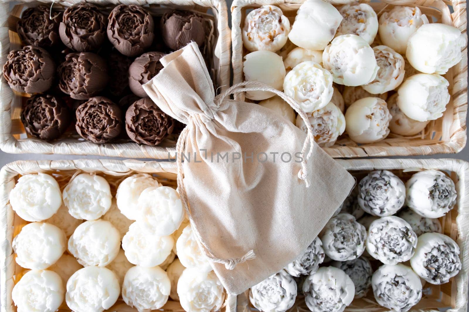 Assorted solid aroma oil in the form of peonies in wooden baskets with linen bag.