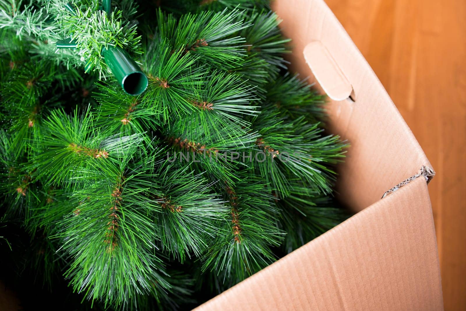 Artificial Christmas tree in cardboard box for holiday decoration.