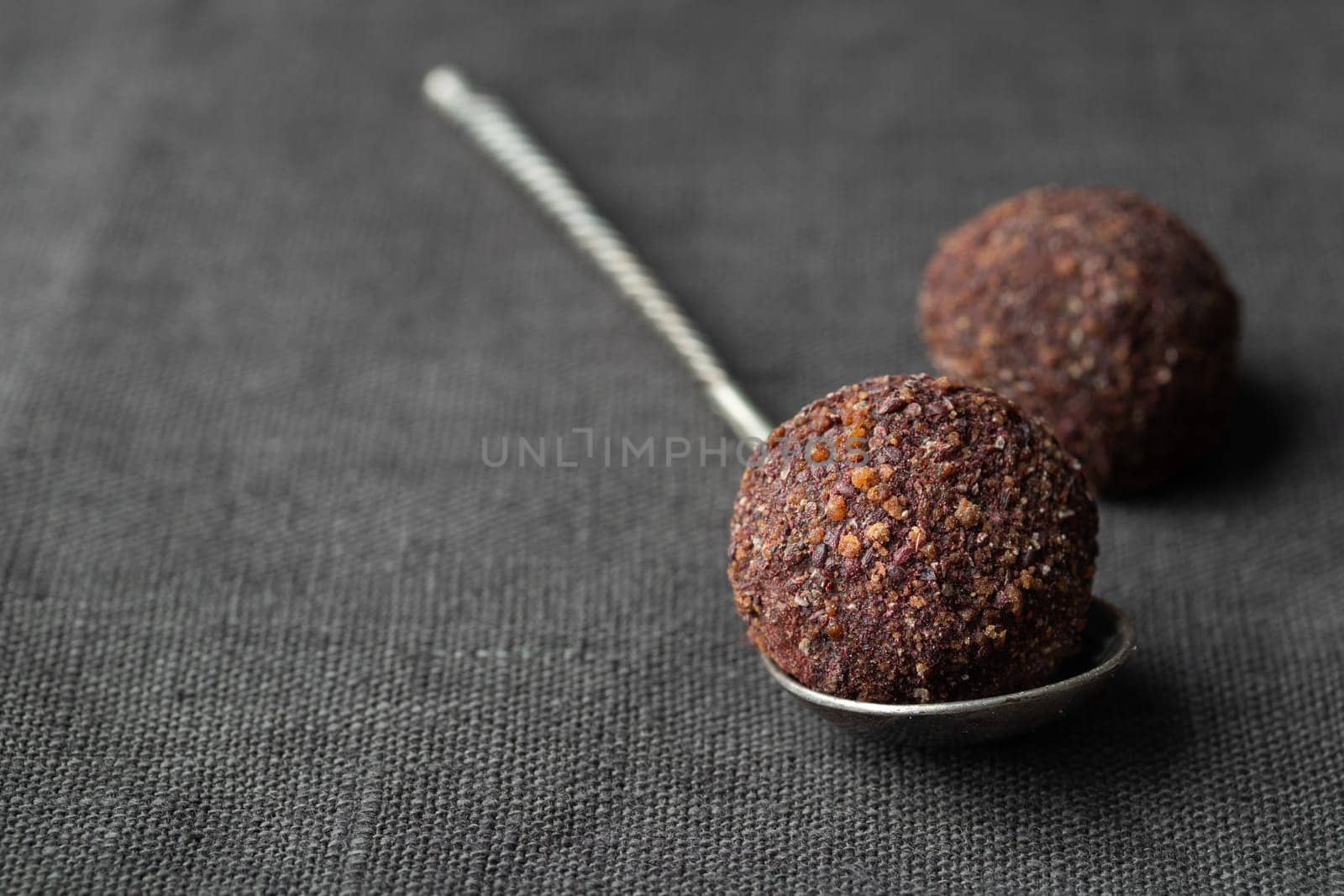 Artisan chocolate truffle candies with berry and fruit filling on dark marble background from confectionary. Handmade or handcrafted bonbons, chocolatier concept. Horizontal banner, copy space