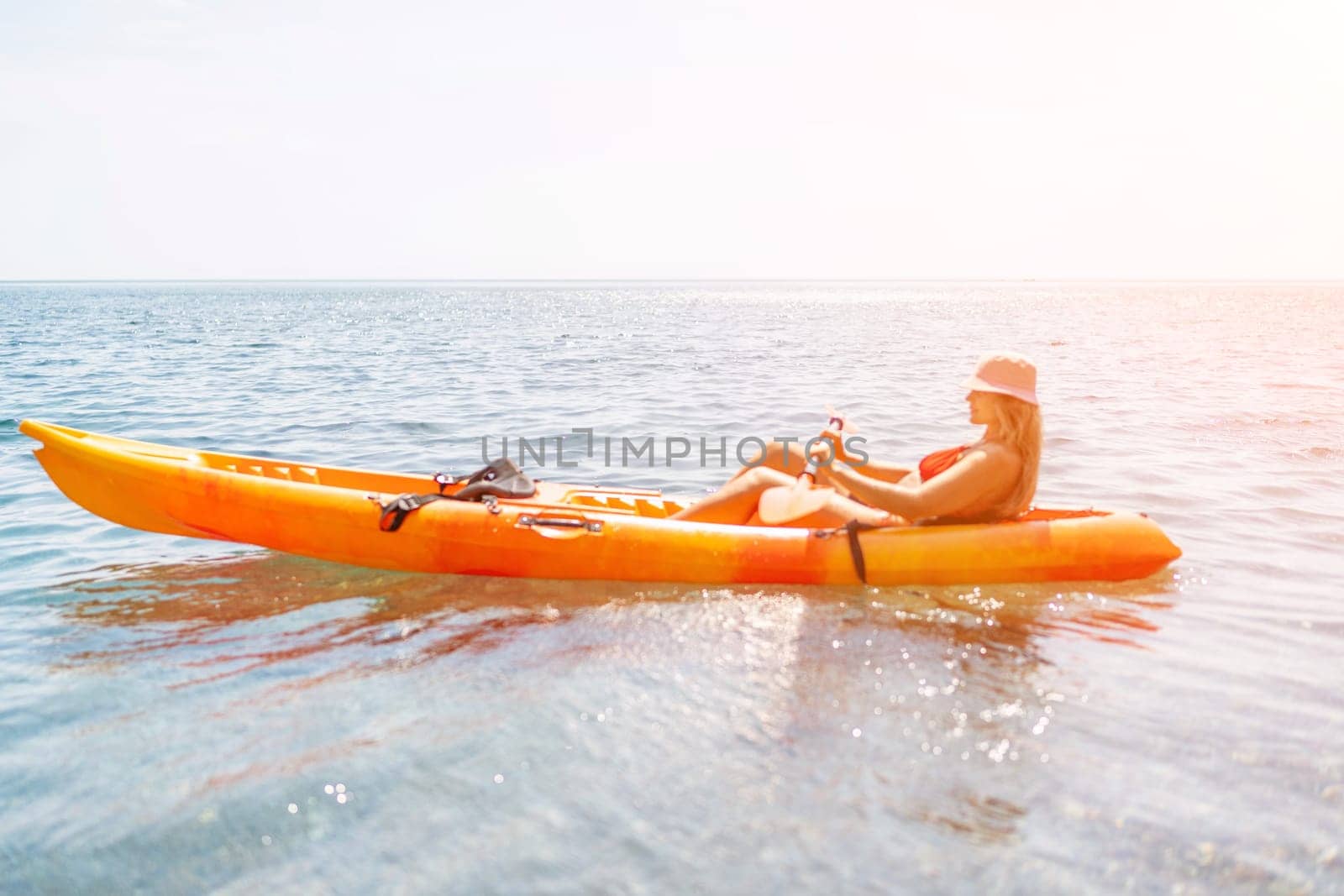 Kayak sea woman. Happy attractive woman with long hair in red swimsuit, swimming on kayak. Summer holiday vacation and travel concept