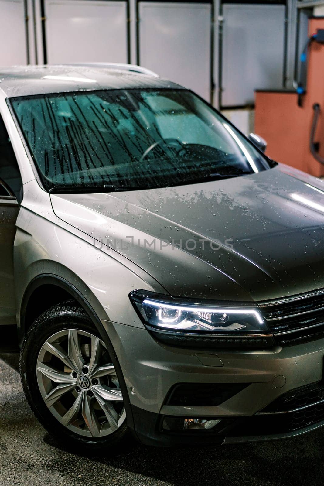 Water drops on the hood and windshield of a car at a car wash. High quality photo