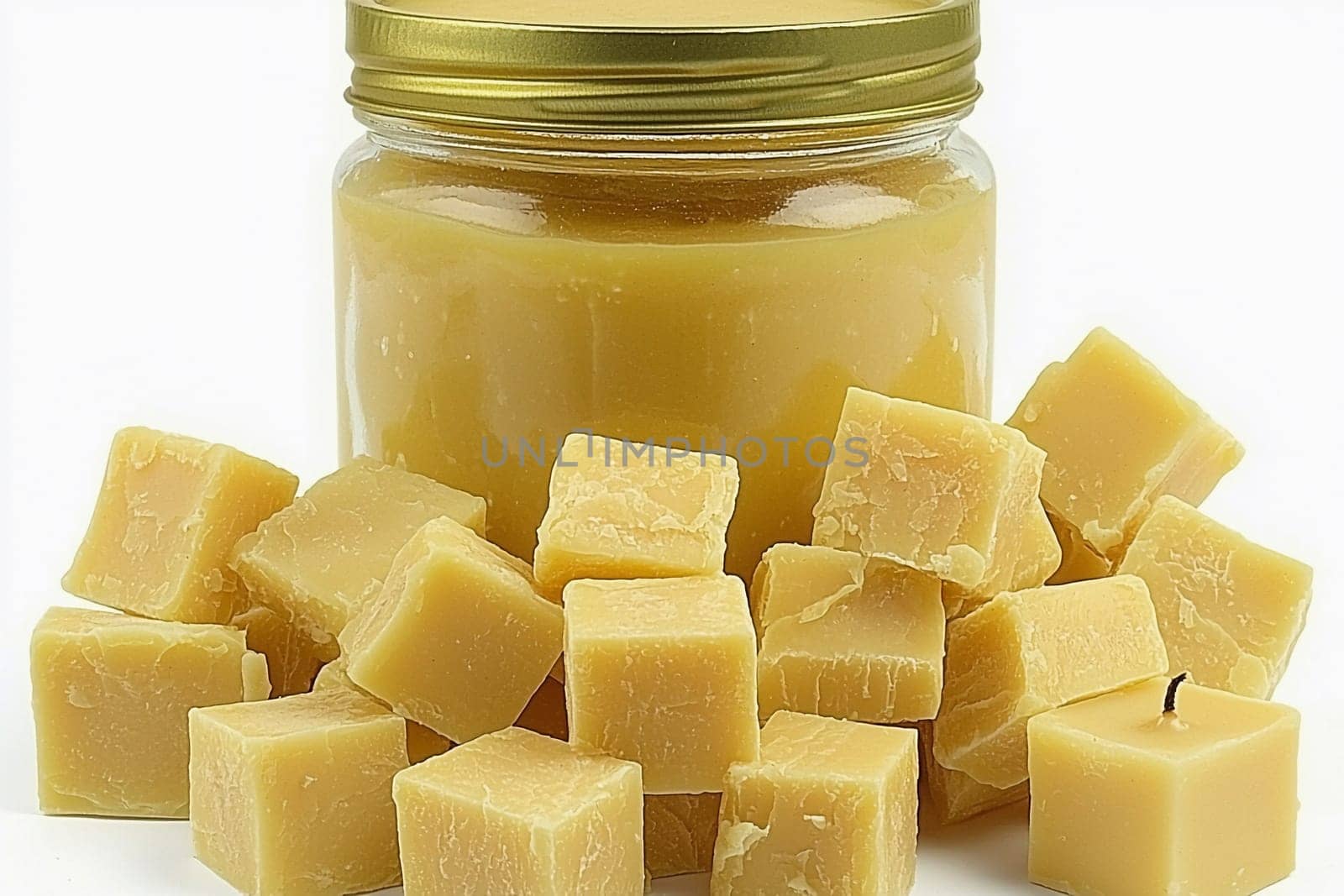Yellow, pure beeswax is displayed in a glass jar alongside neatly cut cubes. They can be used for various crafting activities, including candle making and skincare.