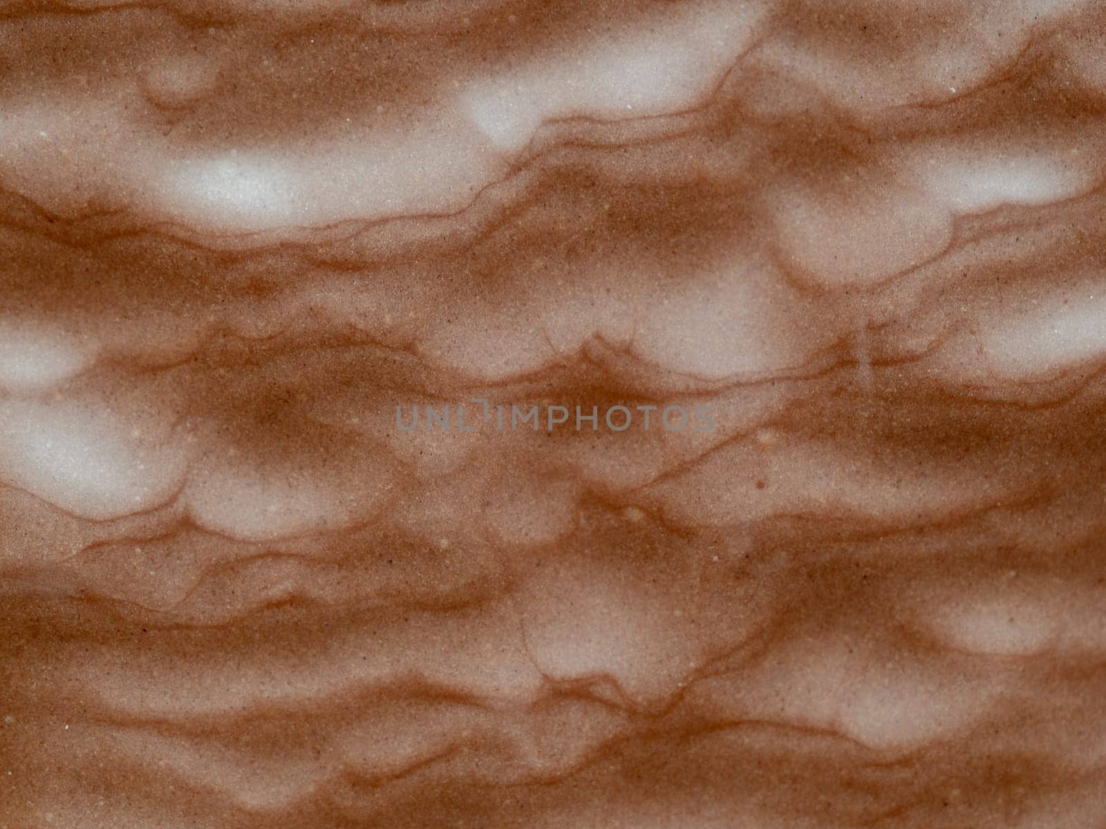 Chocolate bare texture with abstract marble waves lines, close up photo background. Milk chocolate texture as abstract wallpaper background. Sweet food concept