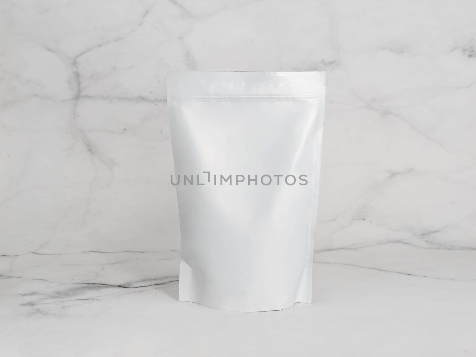 White zipper bag on marble background. Blank packaging white zipper pouch on white marble background ready for food product packaging design mock-up