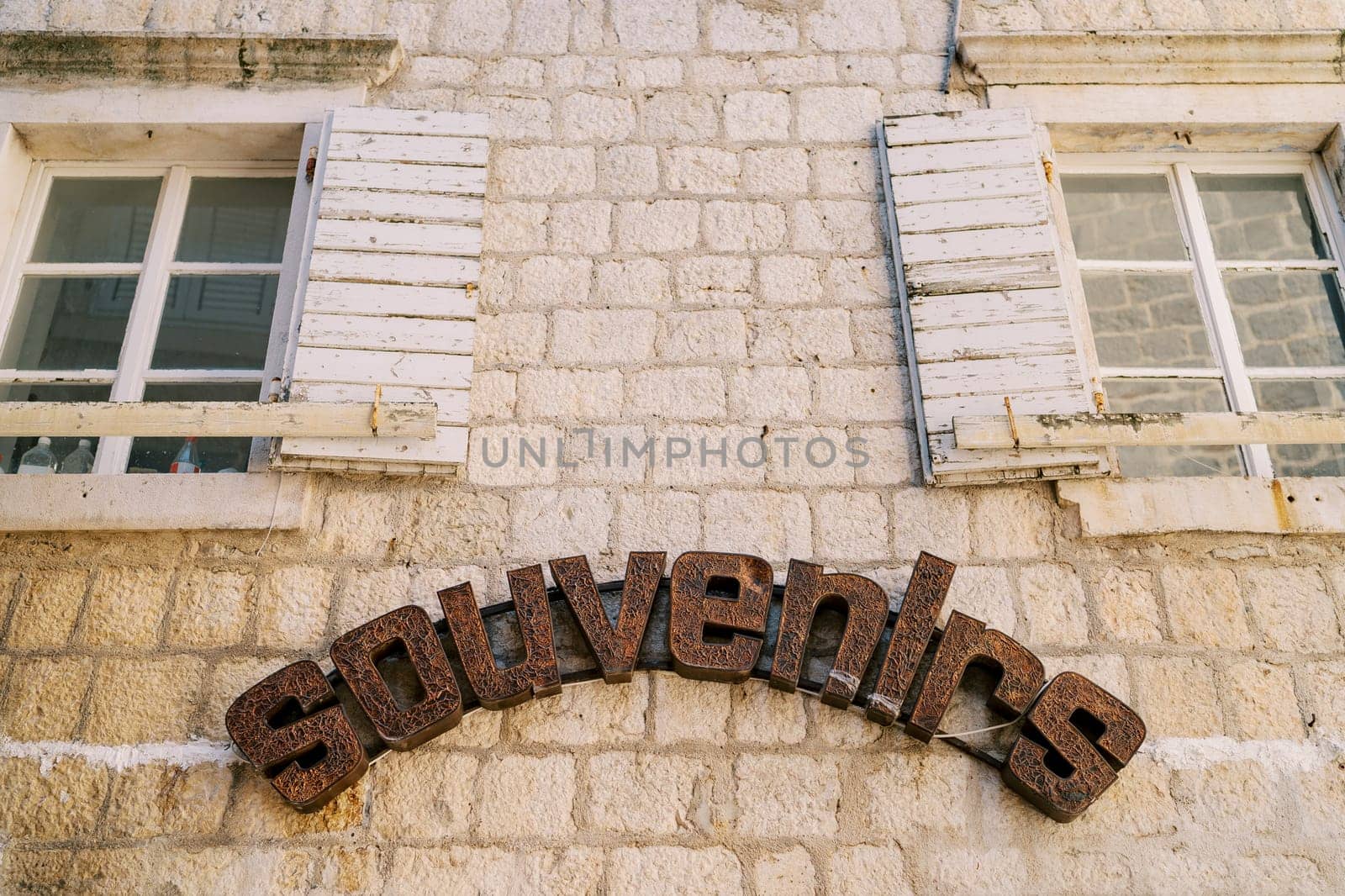 Inscription in a semicircle on the old stone facade of the building. Caption: Souvenirs. High quality photo