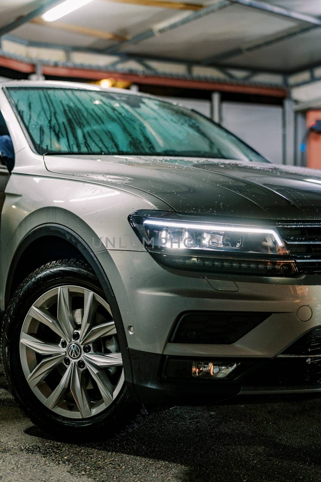 Large SUV with headlights on stands at a car wash. Cropped. High quality photo